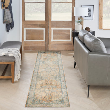 Cozy living room with a vintage-inspired runner rug in cream, teal, and tan, gray sofa, bench, and wooden doors.