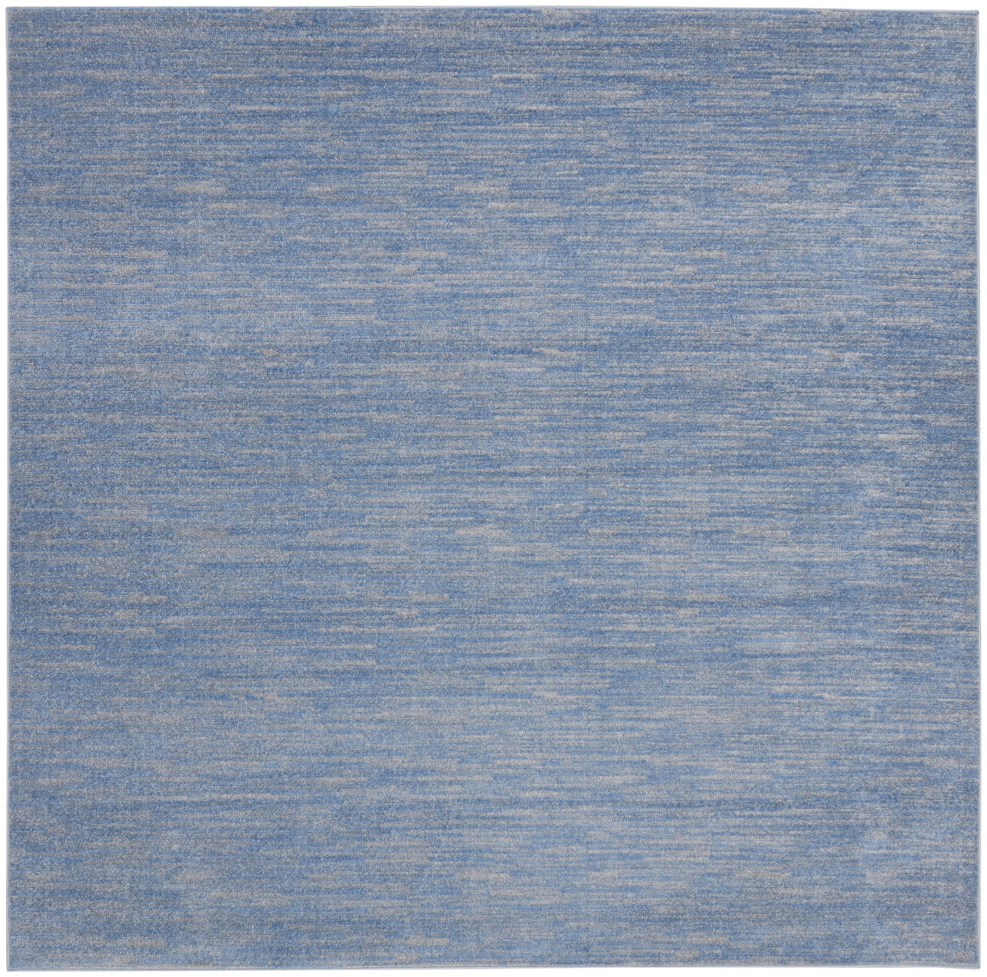 Blue heathered area rug with denim tones; rectangular, soft woven floor covering.