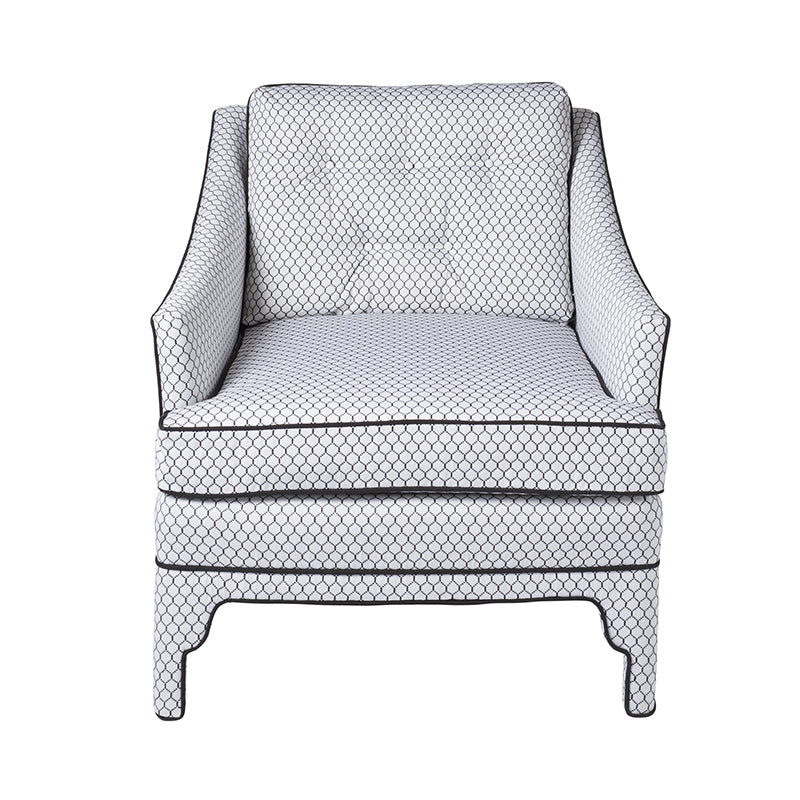 Diamond-patterned white fabric armchair with dark piping, cushioned seat and back, dark wooden legs