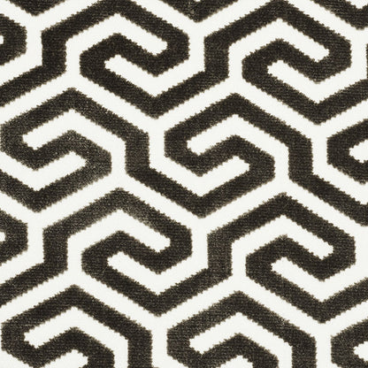 Black and white Greek-key geometric pattern on textured fabric.
