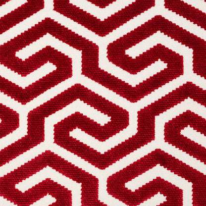 Close-up of red textured rug with interlocking Greek-key maze motifs on white background