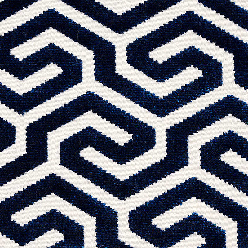Navy blue and white geometric spiral pattern on woven textile, bold interlocking shapes for rug or upholstery.