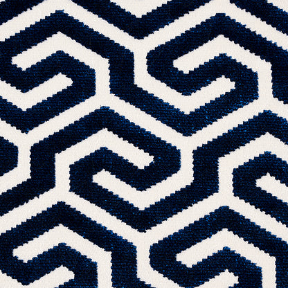 Navy blue and white geometric spiral pattern on woven textile, bold interlocking shapes for rug or upholstery.