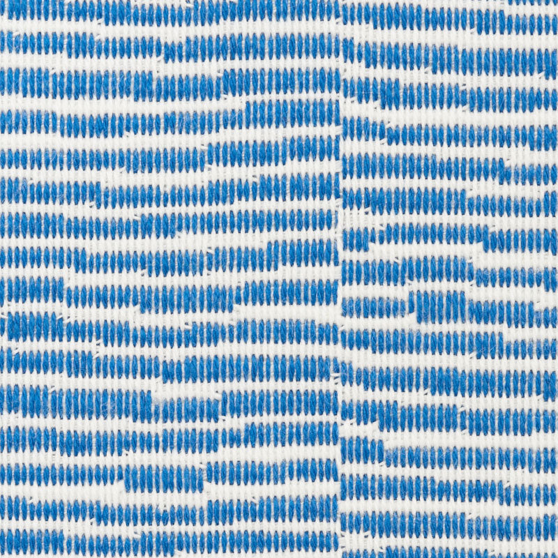 Close-up of blue striped woven fabric with small blue dabs on white background; versatile textile.