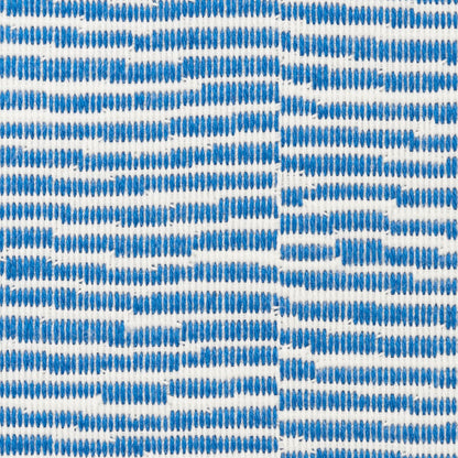 Close-up of blue striped woven fabric with small blue dabs on white background; versatile textile.