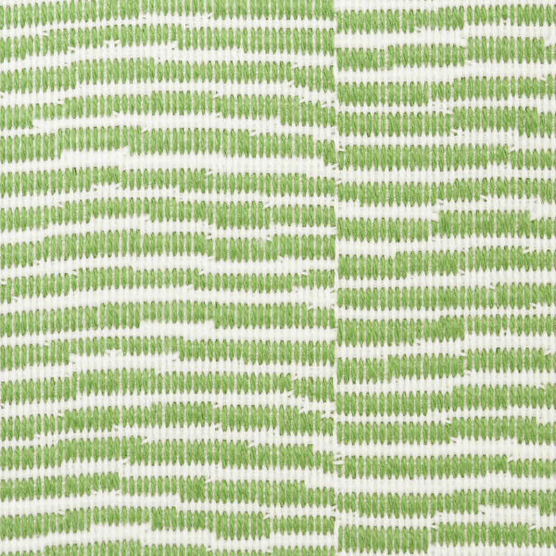 Green embroidered geometric trellis pattern on white fabric, two panels joined by a center seam.