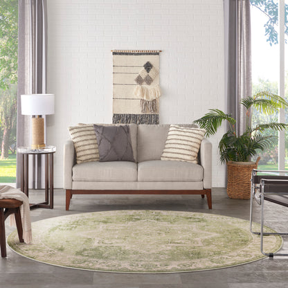 Beige mid-century sofa with striped and gray cushions, round pale-green rug, woven wall hanging, and potted plant.