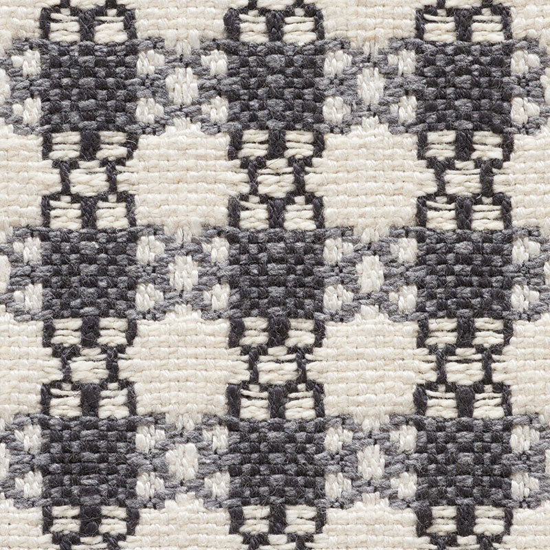 Woven textile with dark charcoal diamond lattice pattern on cream background; sturdy rug/fabric.