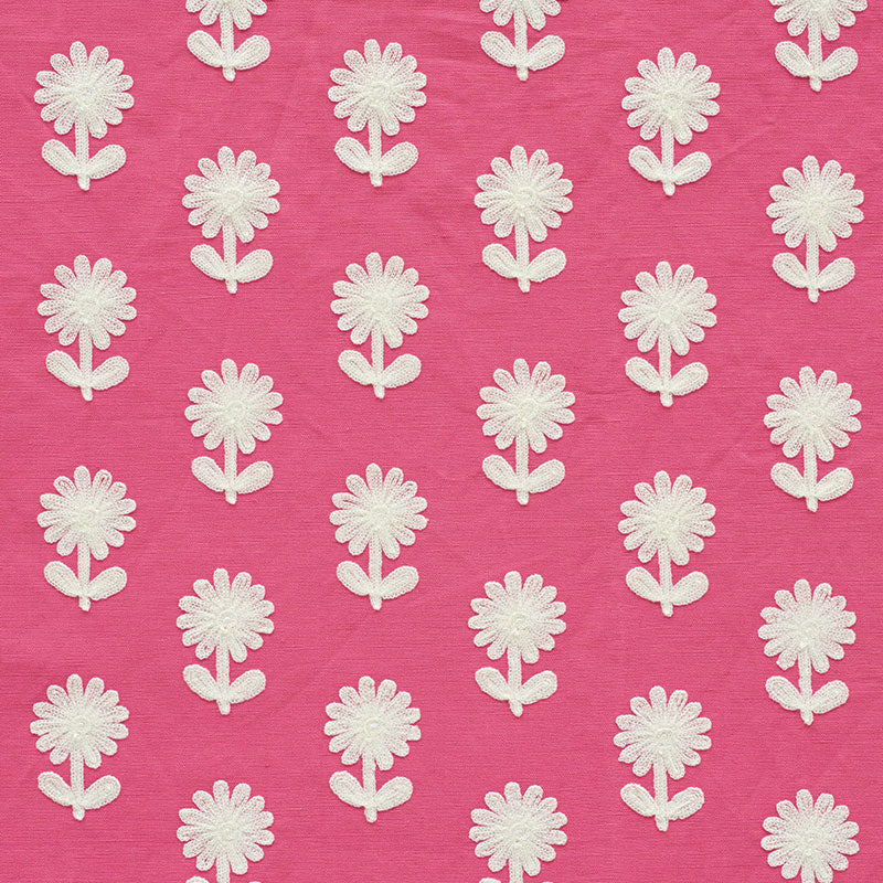 Pink fabric with white embroidered daisy appliqués in a repeating floral pattern.
