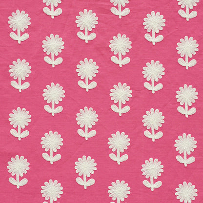 Pink fabric with white embroidered daisy appliqués in a repeating floral pattern.