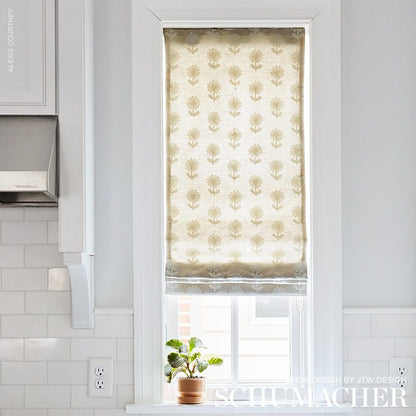 White kitchen window with natural embroidery fabric shade, potted plant on sill, white subway tile backsplash nearby.