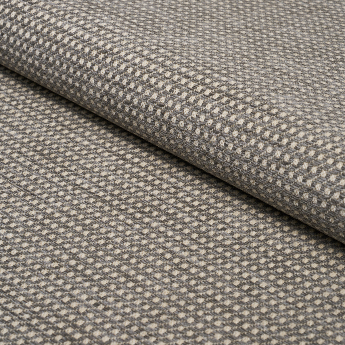 Rolled grey-taupe woven fabric with tiny raised dot pattern; versatile for upholstery, drapery or home decor.
