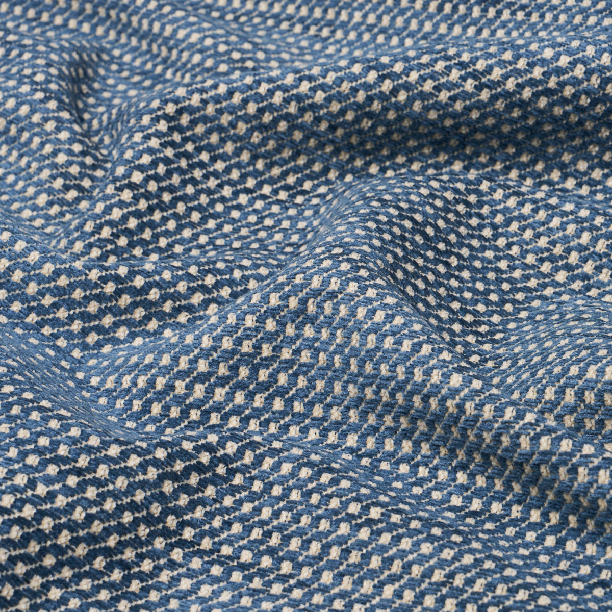 Blue & white dotted woven fabric with tiny white specks in a geometric pattern; soft, textured textile.