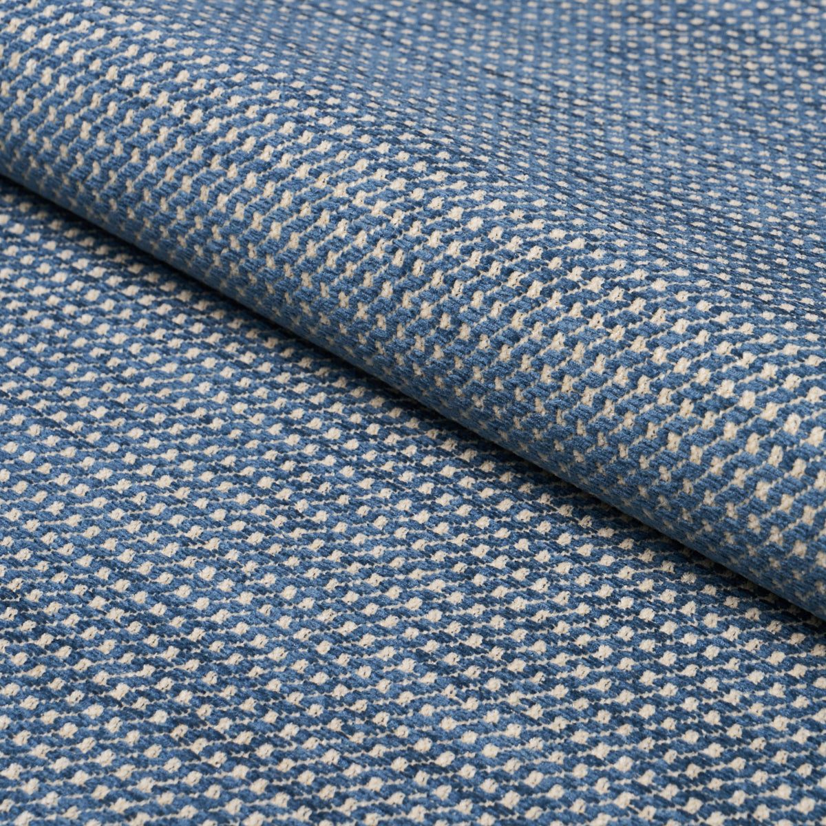 Blue chenille fabric with a tiny cream pattern, folded edge.