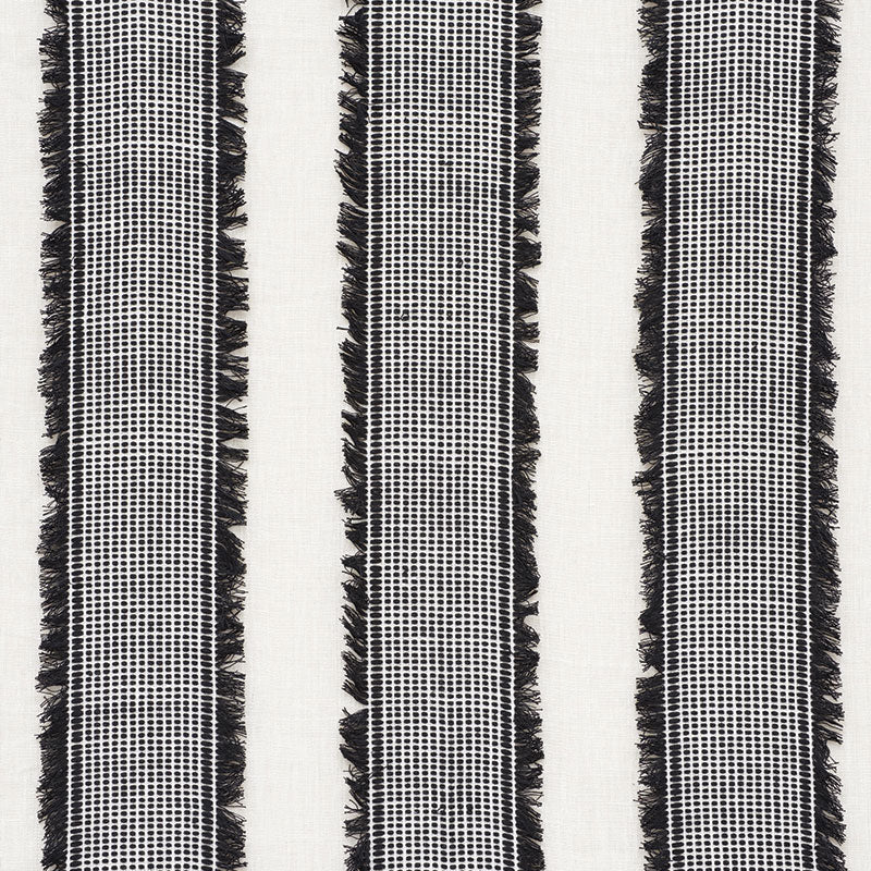 Black and white woven textile with three vertical striped columns and fringe along edges.