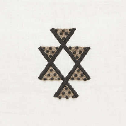 Beige linen with black-stitched triangles forming a star-like cross; beige triangles dotted with tiny black beads.