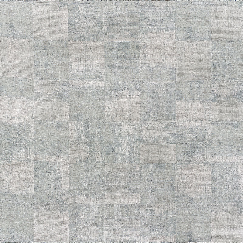 Light gray-blue patchwork rug with distressed square blocks and soft texture.