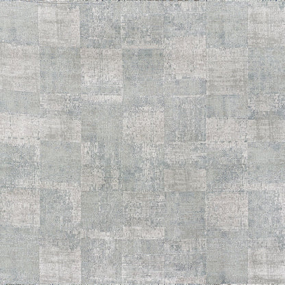 Light gray-blue patchwork rug with distressed square blocks and soft texture.