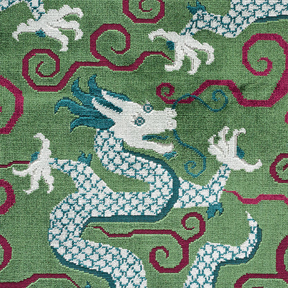 Green textile with white dragon motifs, magenta scrolls and blue accents; ornate decorative rug or wall hanging.