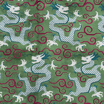 Green fabric featuring repeating white dragons with blue accents and maroon swirls in a textured textile pattern.