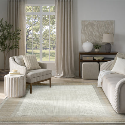 Neutral living room with beige fabric sofa, striped armchair, woven rug, linen curtains, wood console, and green plant.