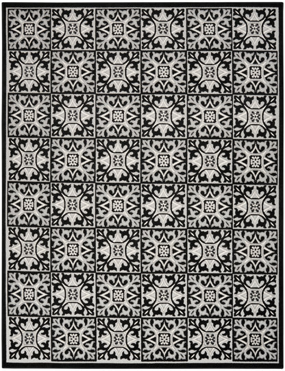 Rectangular area rug with a black border and ivory and black square motifs featuring ornate scrolling floral patterns.