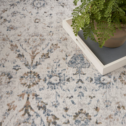 Blue-and-beige oriental rug with floral motifs; potted plant on a white tray rests on the rug.