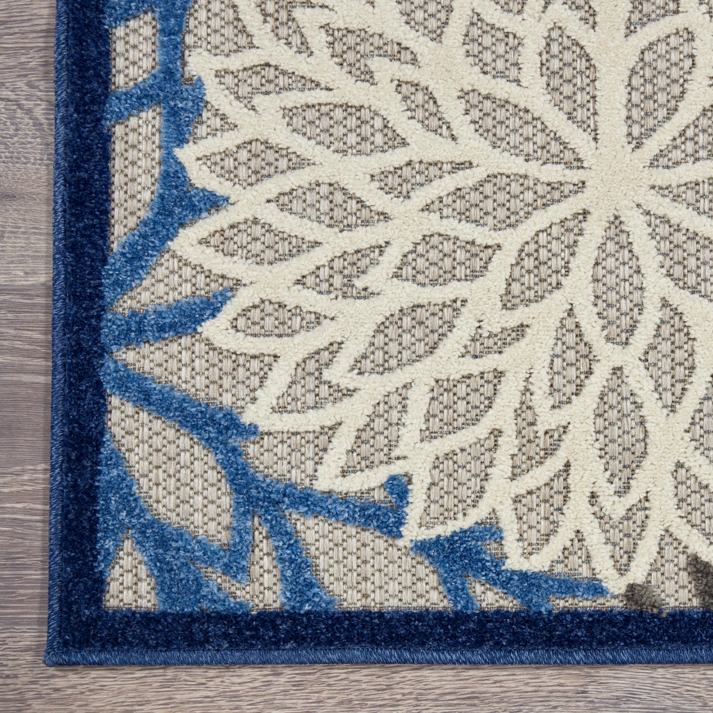 Rectangular woven rug with off-white field, tan leaf lattice motif, & bold navy blue border, 3' x 4'.