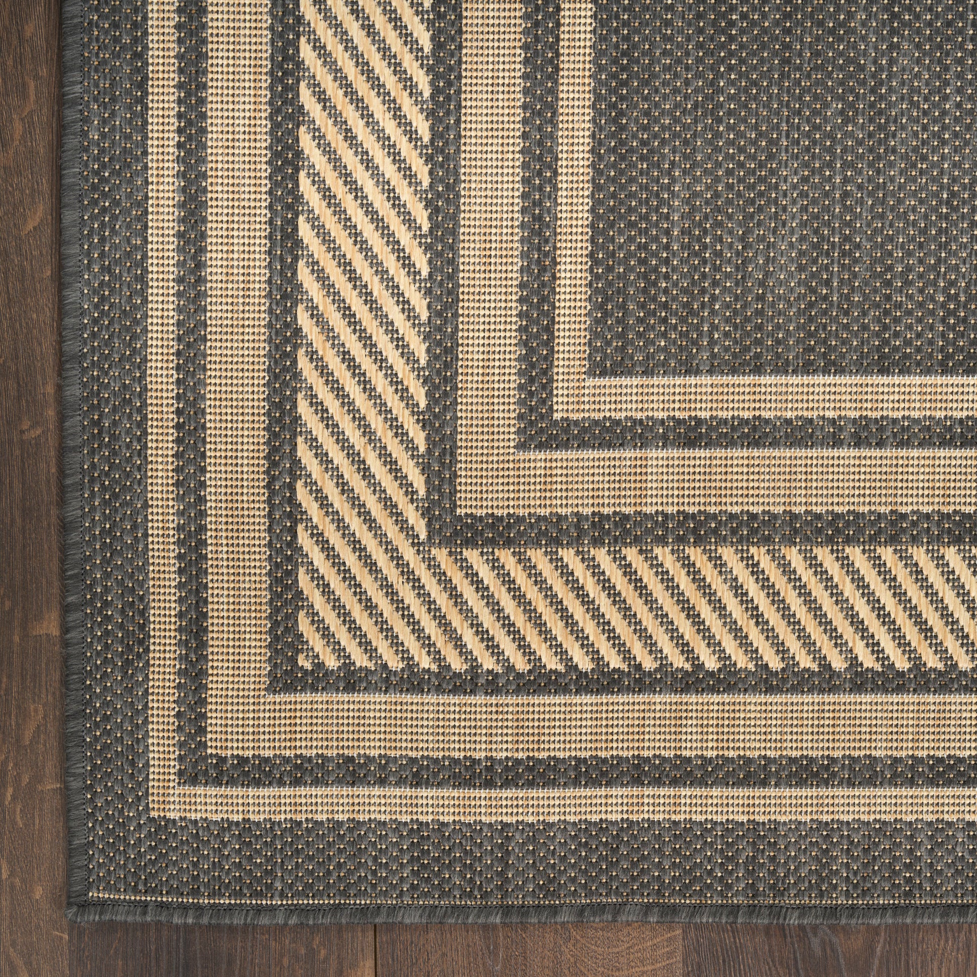 5' x 7' rectangular woven rug with beige and charcoal stripes in nested rectangular frames on a wood floor.