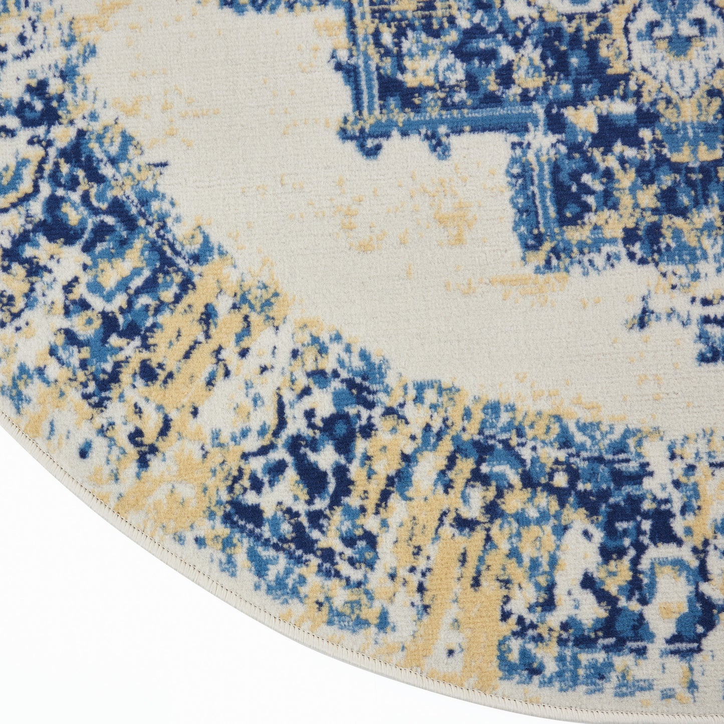 Round area rug featuring abstract blue and beige distressed pattern on ivory backdrop, soft pile with light fringe edge.
