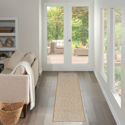 Natural woven jute runner on light wood floor beside a beige sofa, leading to glass patio doors.