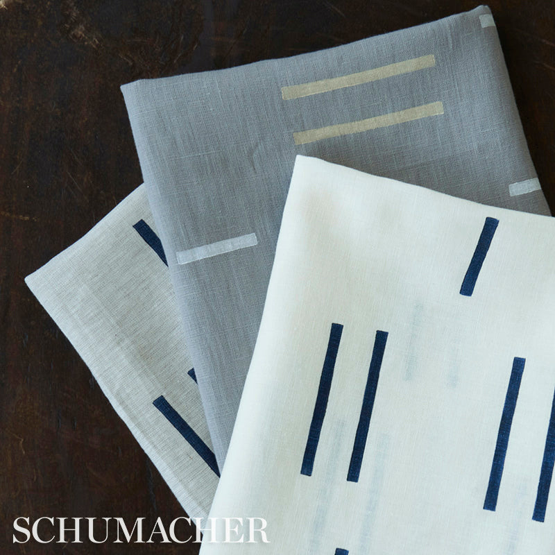 Set of linen napkins in white and gray tones with bold navy and beige vertical stripe patterns.