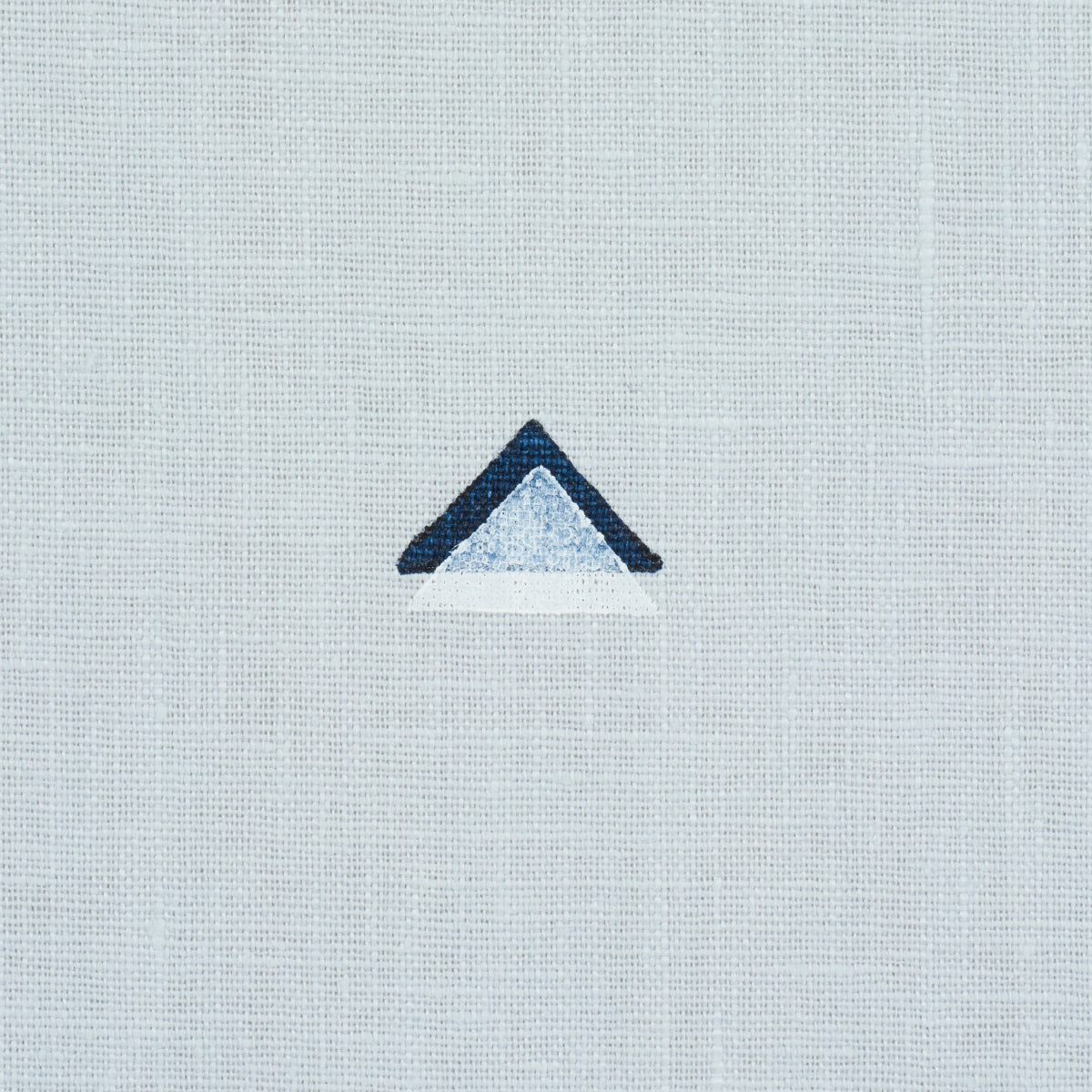 Tiny overlapping navy and white triangle print on sky-blue background.