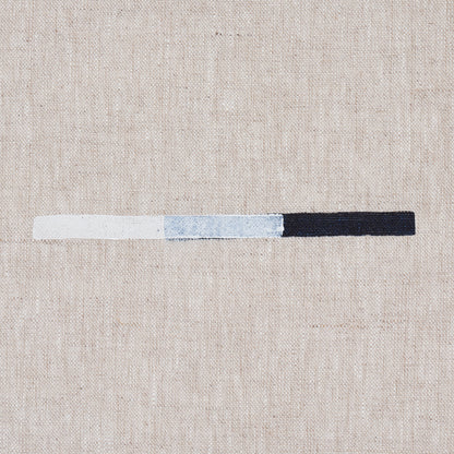 Overlapping dash print in white, light blue-gray, and navy on beige linen background.