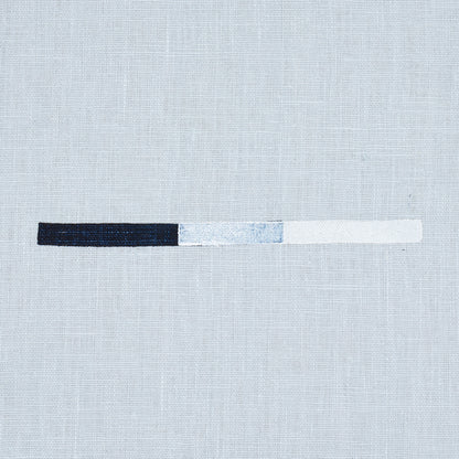 Textile print showing overlapping dash motifs in sky blue on a pale linen background