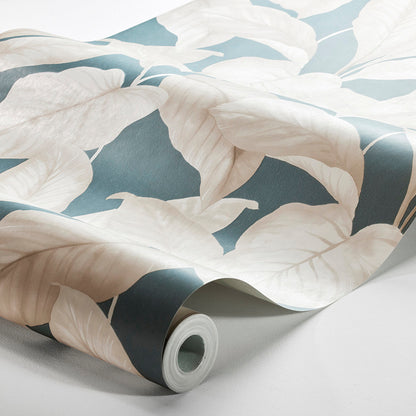 Wallpaper roll with oversized ivory leaves on a blue-gray background; tropical botanical design.