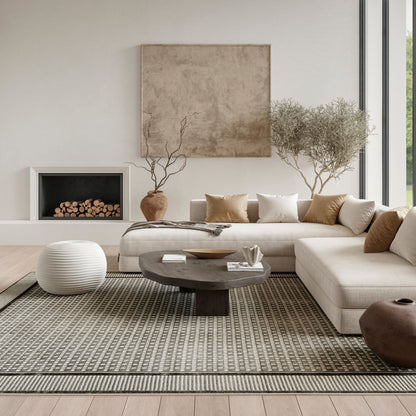 Neutral living room with beige sectional, round dark coffee table, white knit pouf, rug, fireplace, and potted trees.