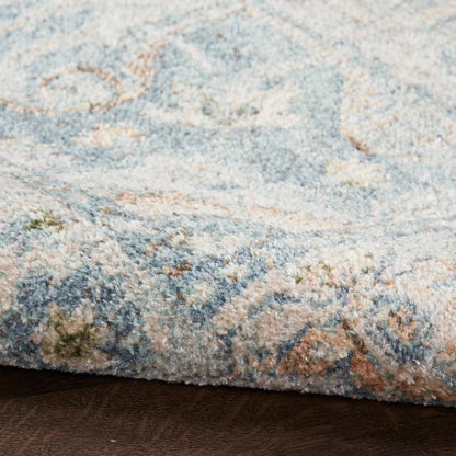 Close-up of a blue & beige patterned rug with light turquoise accents, thick plush pile & folded edge.