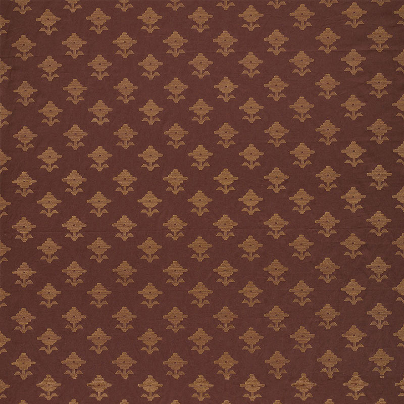 Brown fabric with a repeating tan embroidered flower/trefoil motif; damask-style upholstery textile.