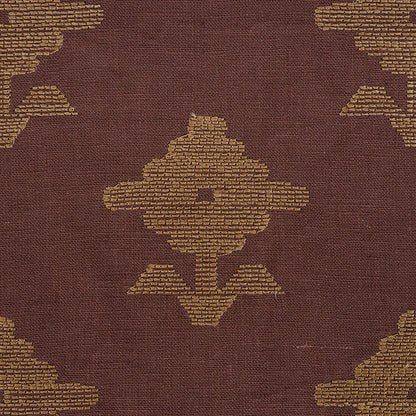 Brown embroidered textile with gold geometric medallion motifs in a kilim-style pattern.