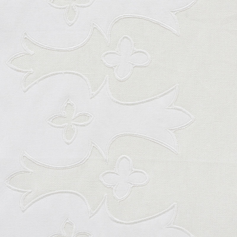 White fabric with tonal applique embroidery of flowing leaf shapes and small flower motifs
