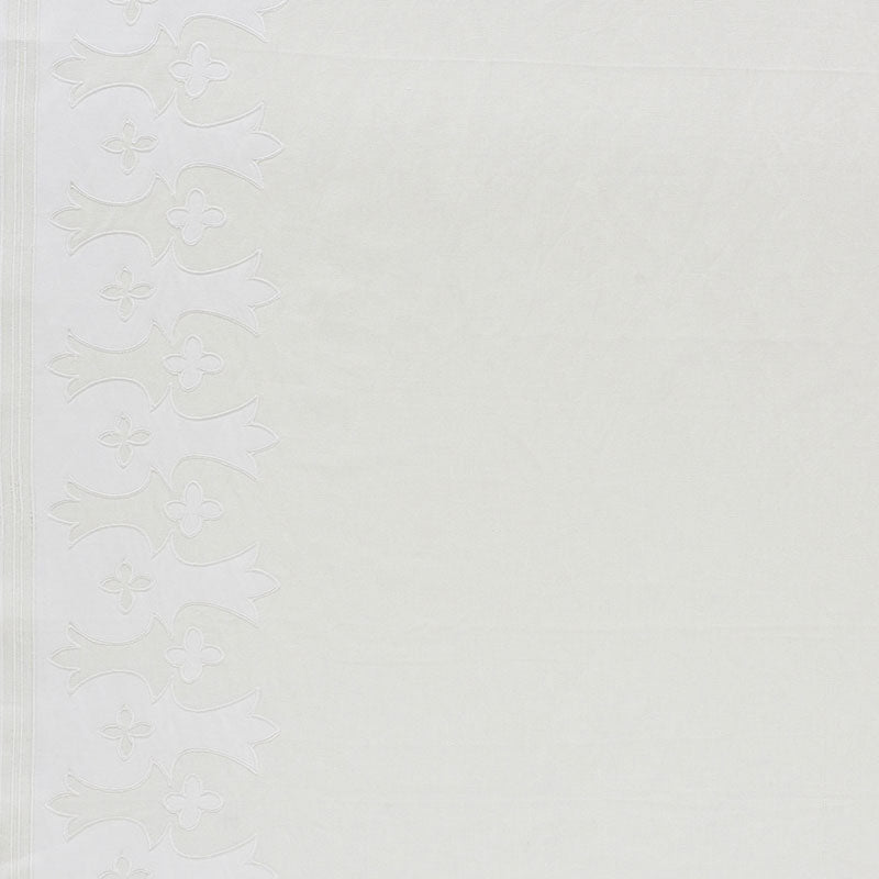 White embossed wallpaper border with vertical floral scroll design along the left edge on a cream textured background.