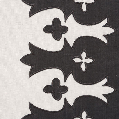 Cream fabric with bold black fleur-de-lis embroidery motifs in a vertical repeating pattern; high-contrast upholstery textile.