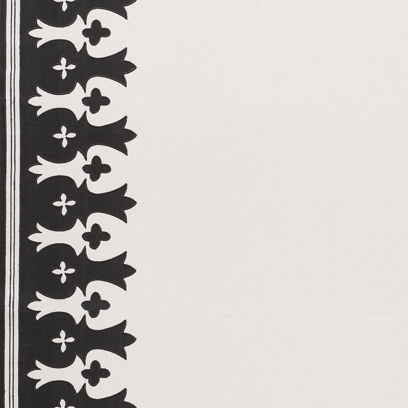 Cream textile with a black vertical border featuring repeating fleur-de-lis motifs along the left edge.
