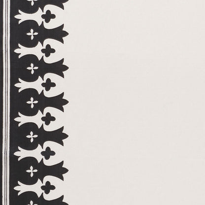 Cream textile with a black vertical border featuring repeating fleur-de-lis motifs along the left edge.