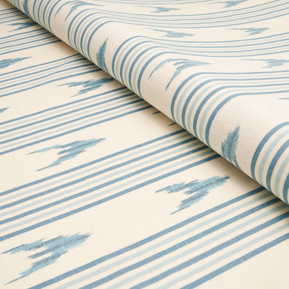Cream fabric with blue ikat-inspired stripes, rolled edge; lightweight woven textile for curtains or upholstery.
