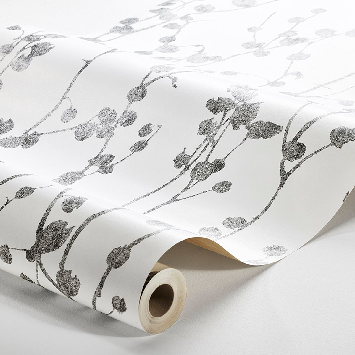 Rolled charcoal wallpaper with a silver-gray metallic botanical vine pattern.