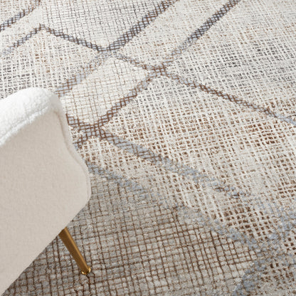 Beige geometric woven rug with light blue grid lines; partial white upholstered chair and wooden leg visible.