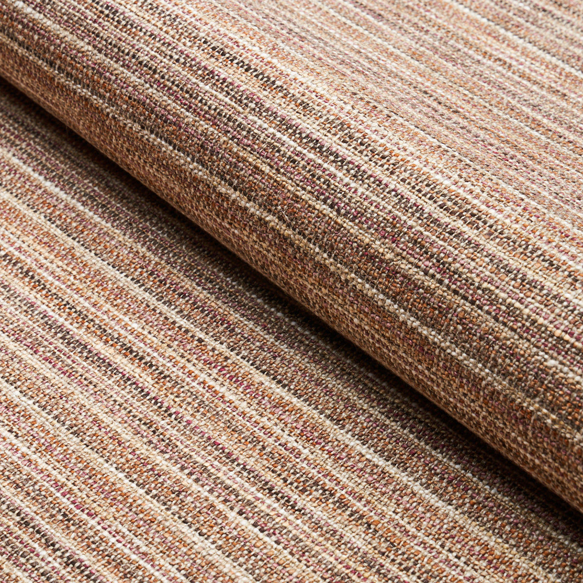 Rolled brown striped woven fabric rug with earthy beige and tan tones and a textured weave.