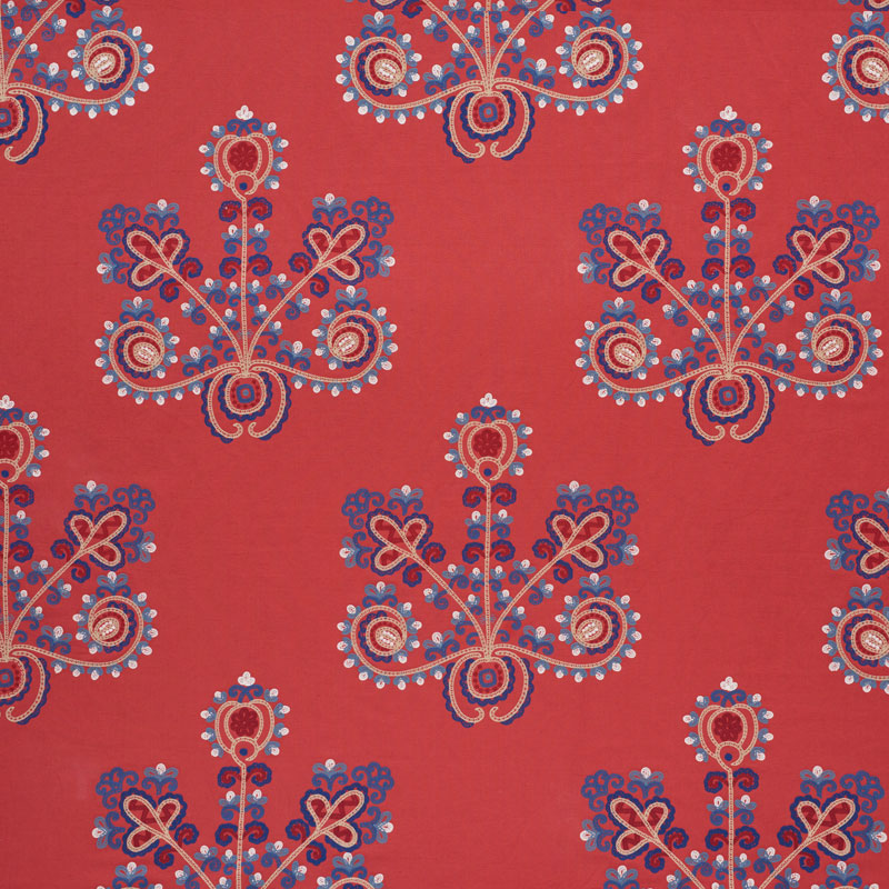 Vermilion fabric with repeating blue and white ornate botanical medallions and pink accents.